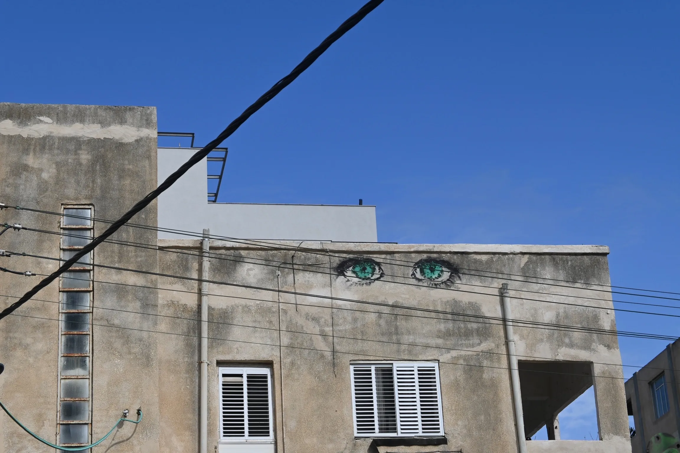 Watchful eyes painted on the face of a weathered building