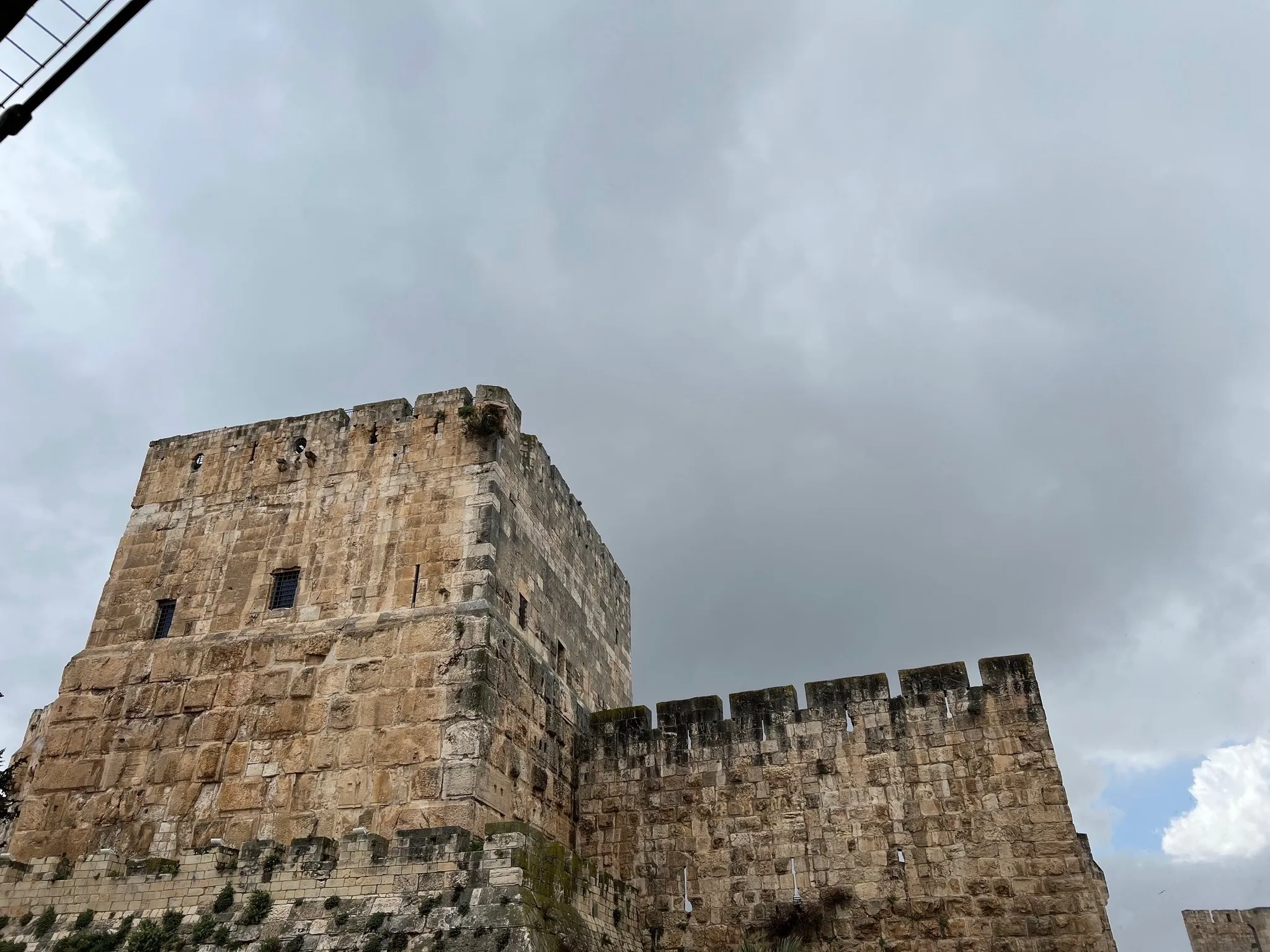 Old City ramparts and a corner watchtower under a storm sky